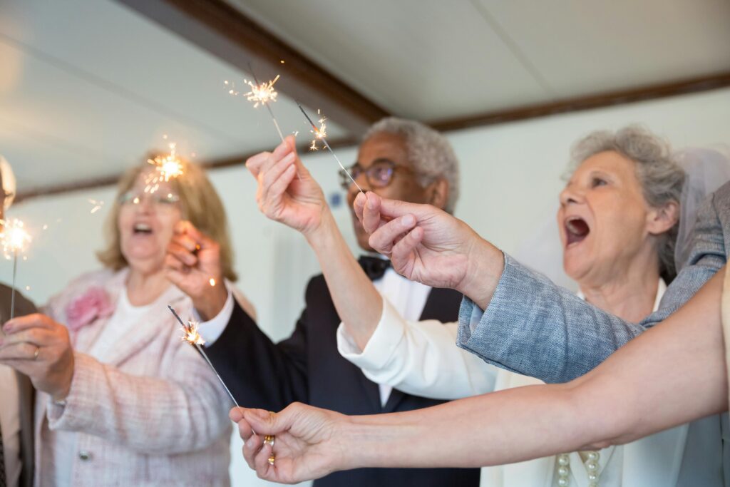 pexels-photo-8791084-8791084 Elderly friends joyfully celebrate indoors holding sparklers. Embracing togetherness and fun.